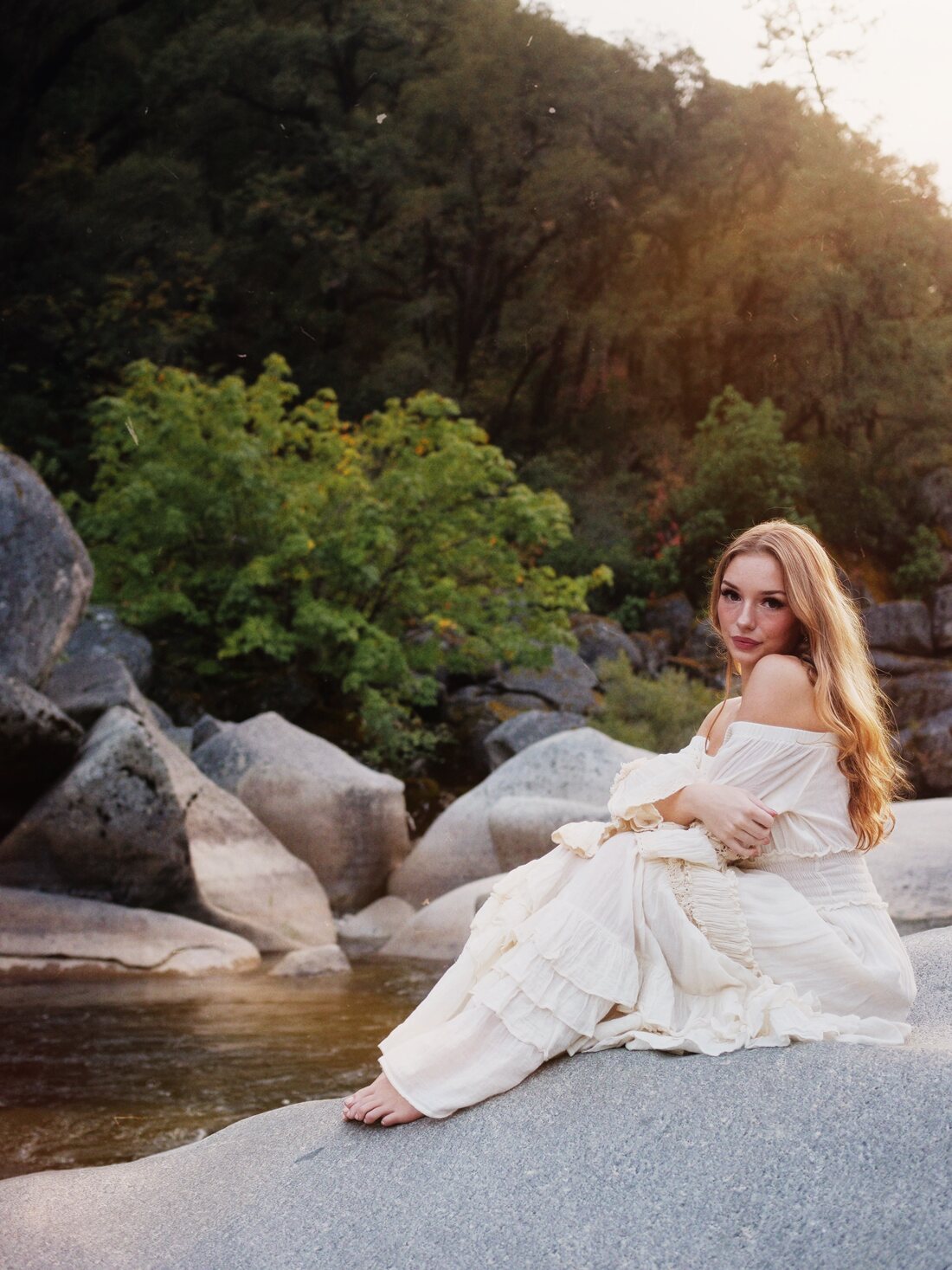 Izzy seated beside the river at golden hour